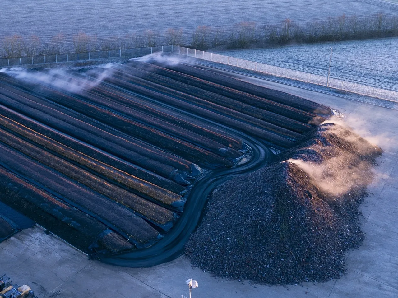 Andains de compost qui fument dans le froid du matin.